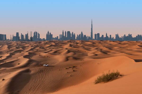 Dubai sand dunes at sunset with the city of Dubai behind